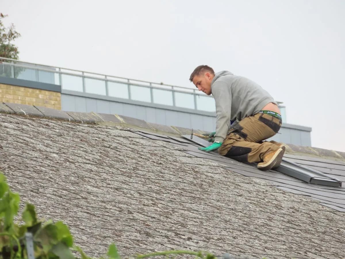 Roofing contractor installing shingles on a home